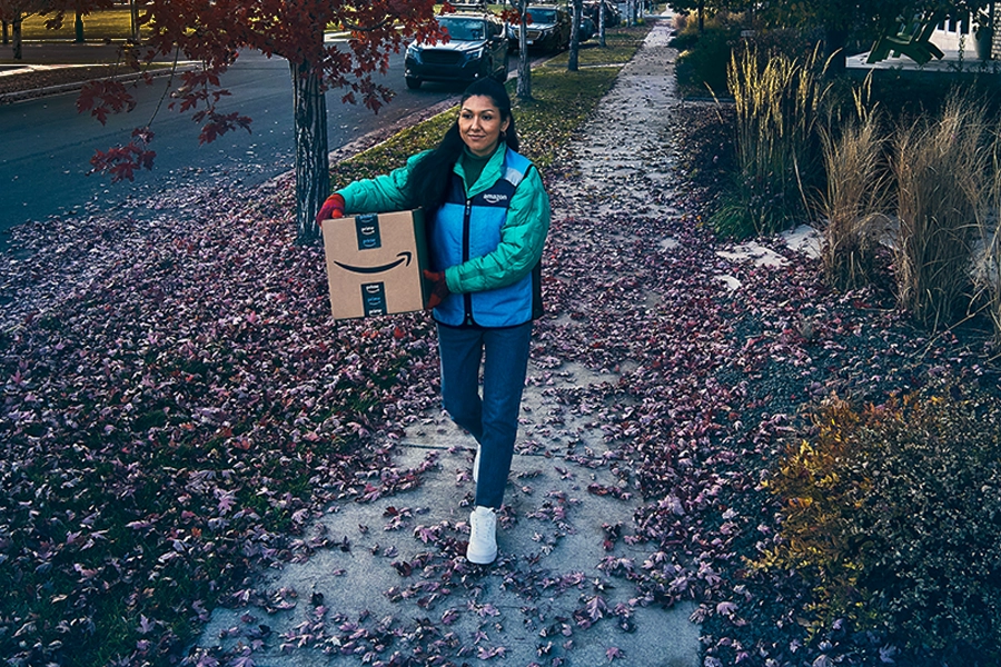 Woman delivering package in dark, autumn weather