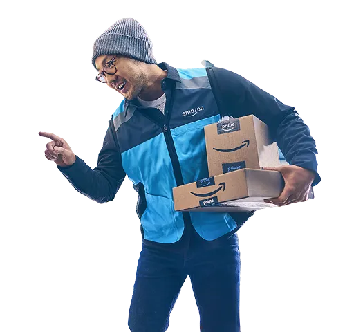 A man holds two packages and rings the doorbell of an apartment building.